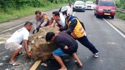 Bhabinkamtibmas Bersama Warga Bersihkan Bongkahan Batu di Jalan Trans Sulawesi